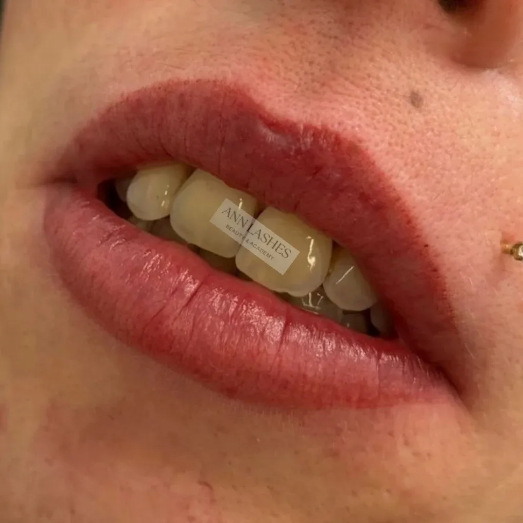 Lächeln nach einer Permanent-Make-up-Behandlung der Lippen